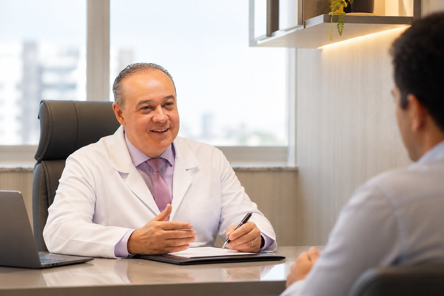 Dr. Vinicius explicando um exame a um paciente, em seu consultório.